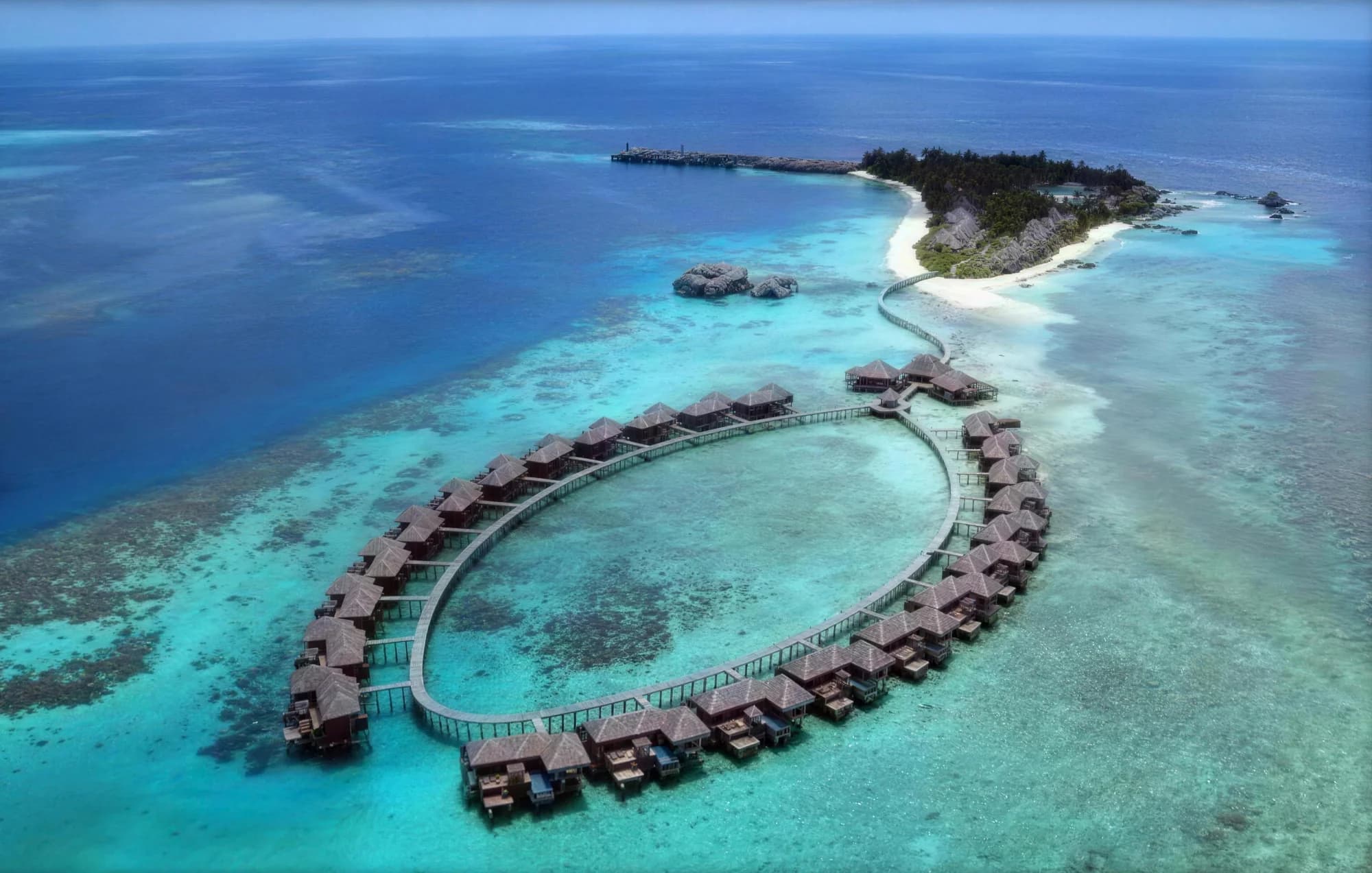 Aerial view of a ring of water villas at Coco Palm Boduhithi