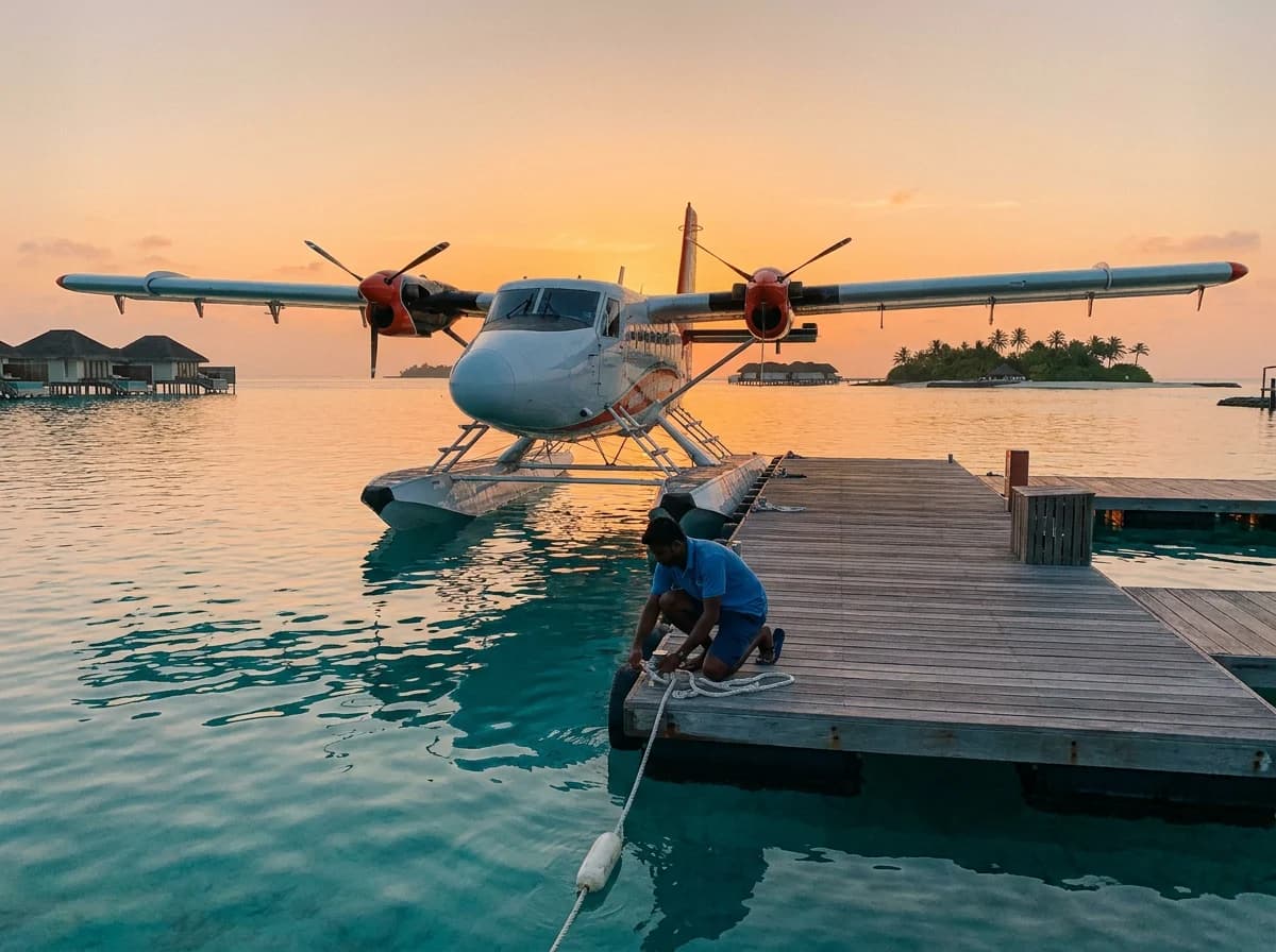 Seaplane moored at a floating dock on a Maldivian lagoon at sunrise