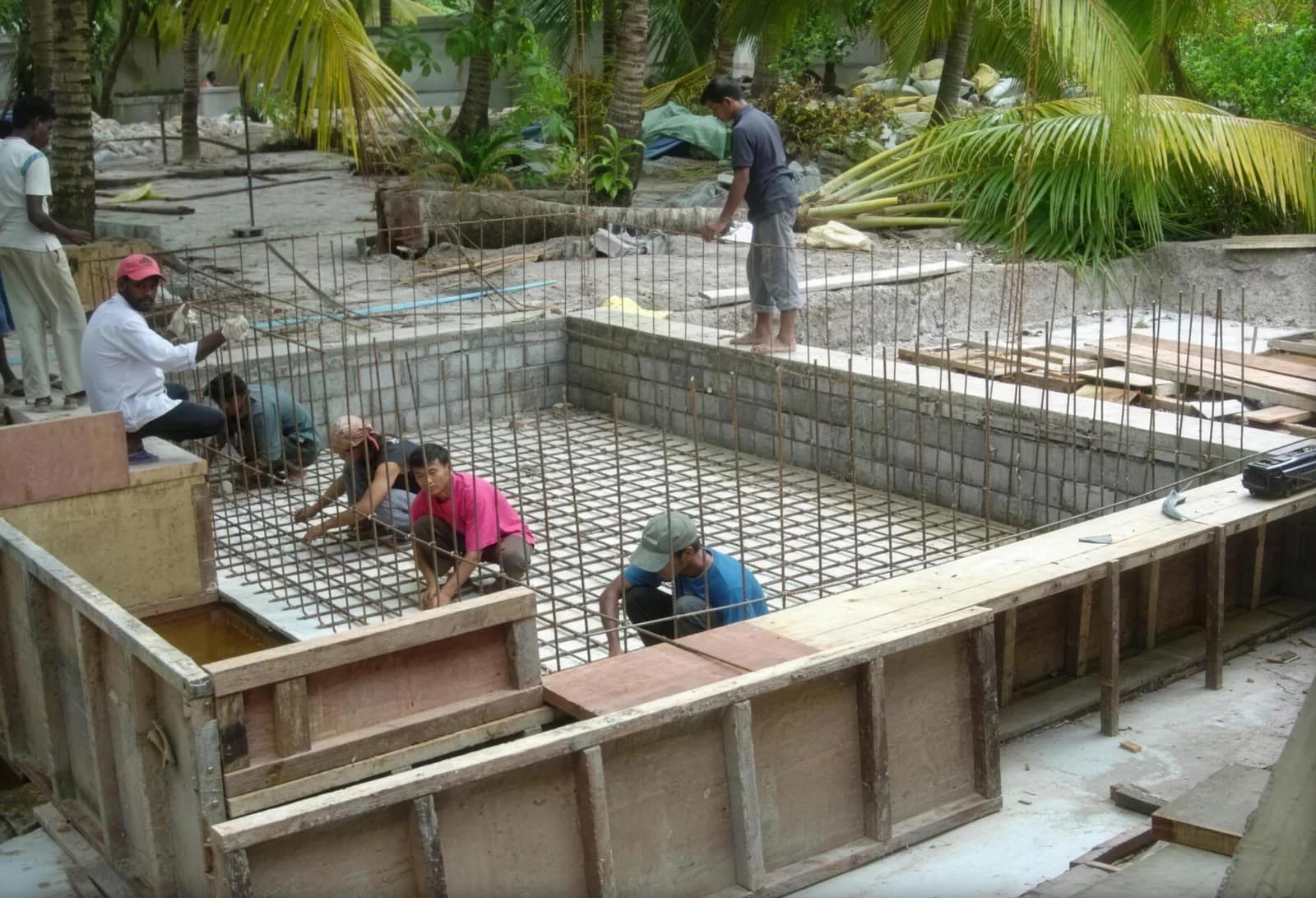 Workers placing reinforcement and formwork on a resort island site